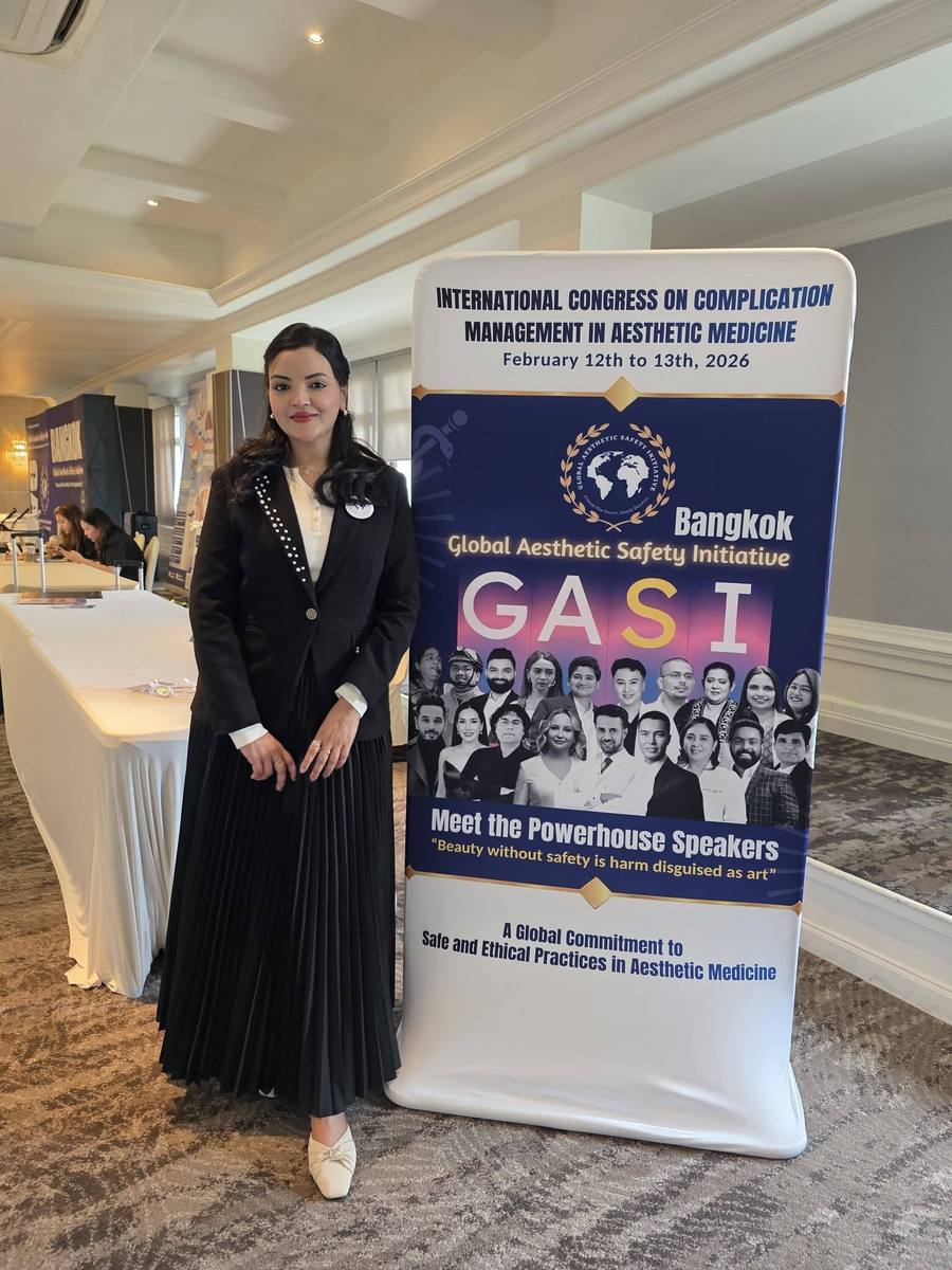 Dr. Tasmin Tahnin Siha standing in front of the banner for the International Congress on Complication Management in Aesthetic Medicine, Bangkok.