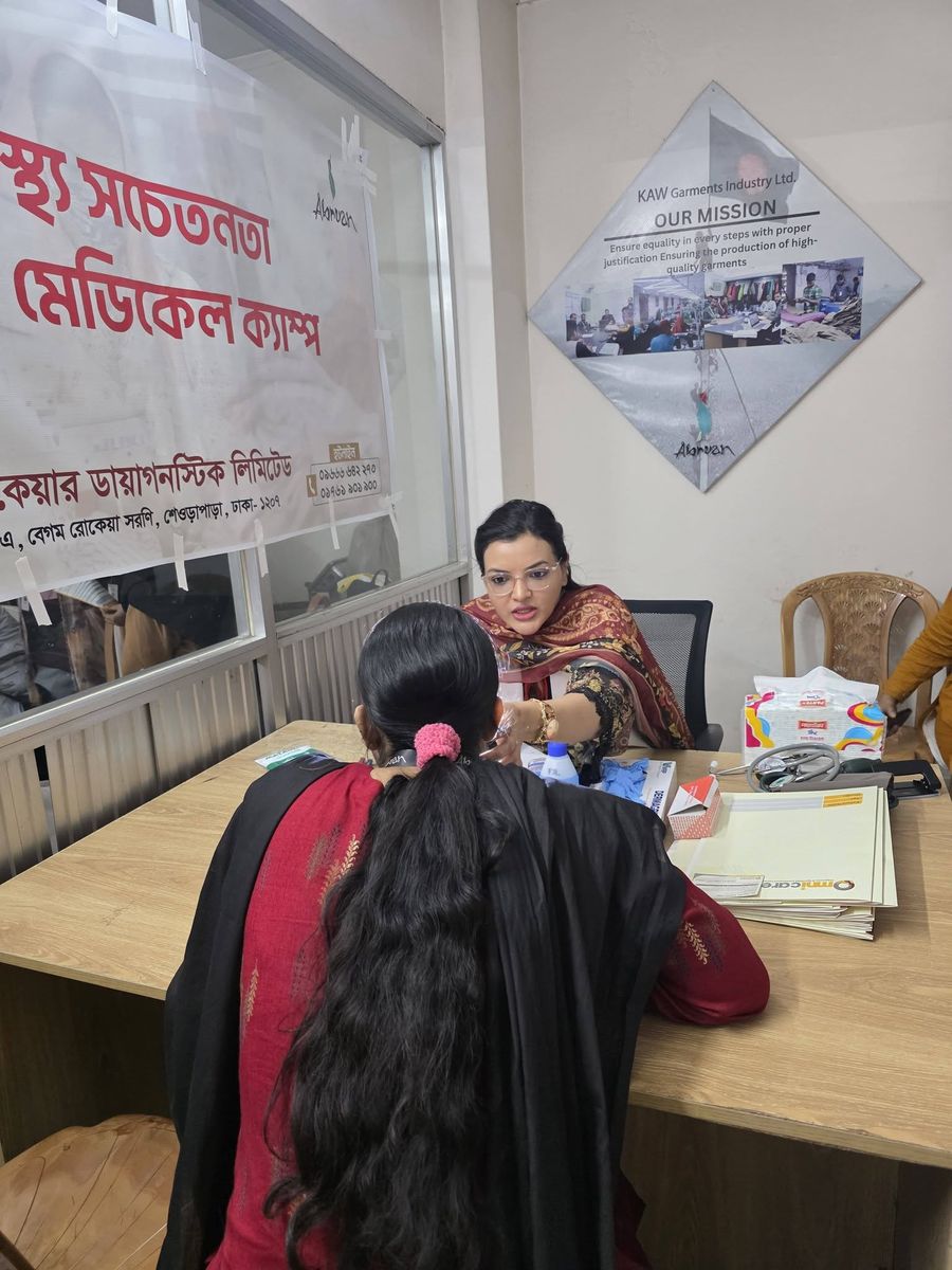 Dr. Tasmin Tahnin Siha, seen from the front, consulting with a patient at a community health awareness medical camp.